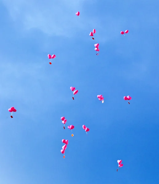 stock image Red balloons with the messages in the blue sky