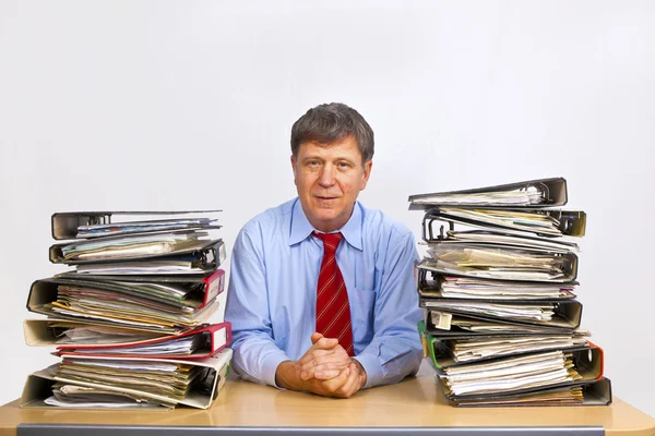 Mann studiert Ordner mit Akten am Schreibtisch im Büro — Stockfoto