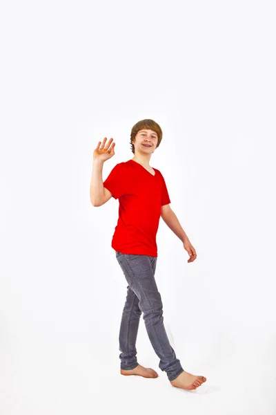 Portrait of happy teenage boy walking in studio — Stock Photo, Image