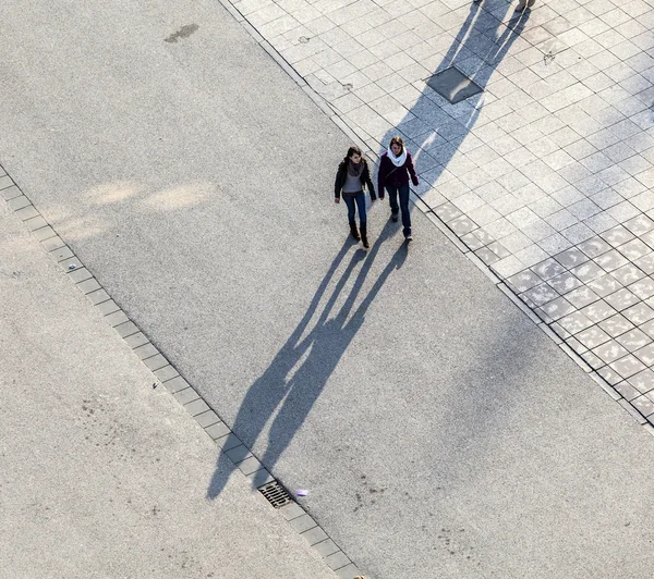 Caminando por la calle con largas sombras — Foto de Stock