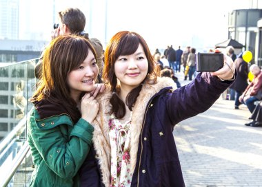 Japanese tourists take self-portraits clipart