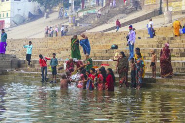 Hindu wash themselves in the river Ganga in the holy cit clipart