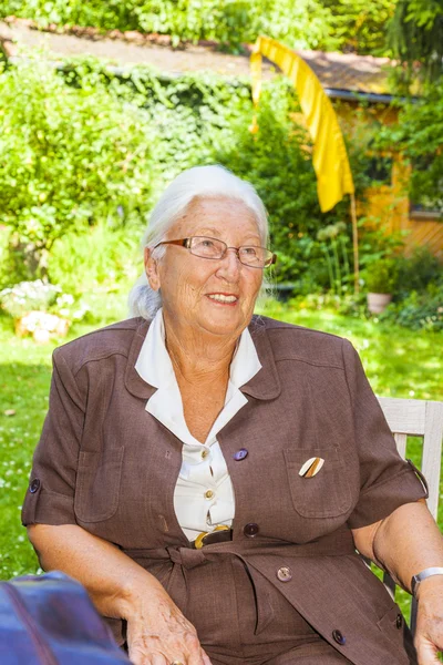 Senior vrouw geniet zittend in haar — Stockfoto