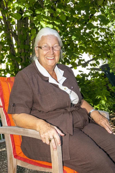 Äldre kvinna har sitter i hennes — Stockfoto