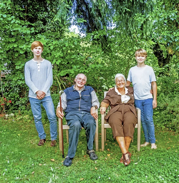 Розширена сімейна група позує в саду з бабусею і дідусем — стокове фото