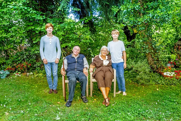 Grupo familiar estendido posando no jardim com avós — Fotografia de Stock