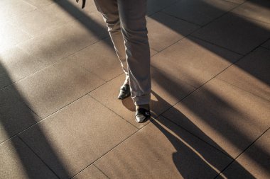 Feet of hurrying in the airport with sown shadows clipart