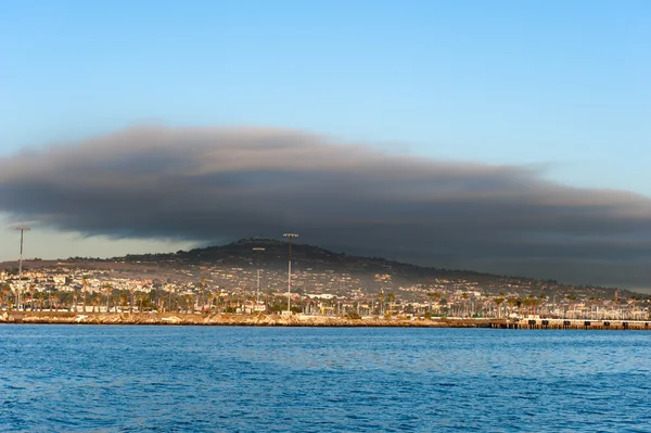 Dark cloud over oceanfront land — Stock Photo, Image