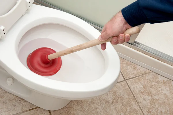 Plumber uncloging toilet — Stock Photo, Image
