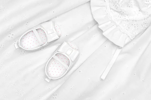Baby shoes on dress — Stock Photo, Image