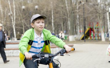 Çocuk bisiklete biniyor