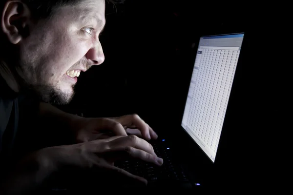 stock image Man working on laptop in the dark