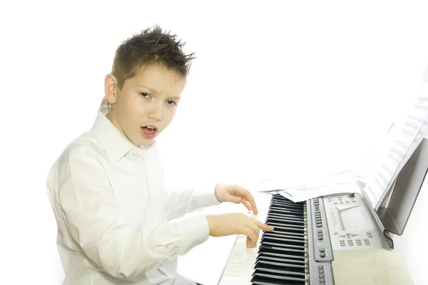 Мальчик играет на фортепиано — стоковое фото