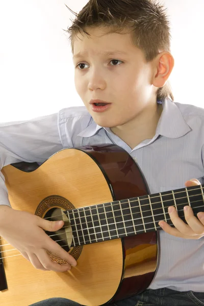 Niño con una guitarra acústica aislada en blanco — Foto de Stock