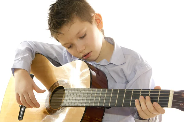 Niño con una guitarra acústica aislada en blanco — Foto de Stock