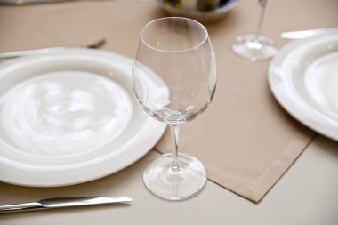 Wine glasses set at reataurant table clipart