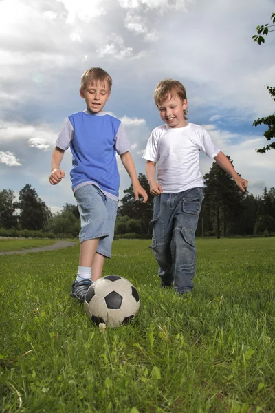 Dois menino feliz jogar no futebol — Fotografia de Stock