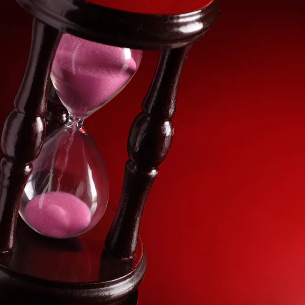 Reloj de arena sobre fondo rojo — Foto de Stock
