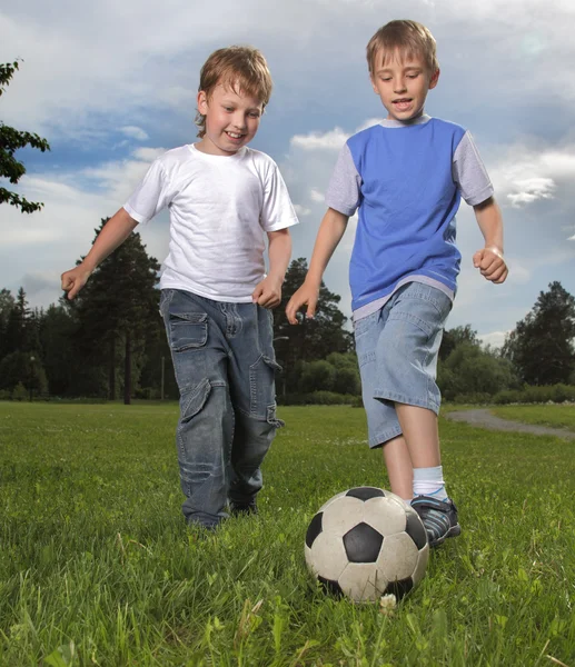 Два счастливых мальчика играют в футбол — стоковое фото