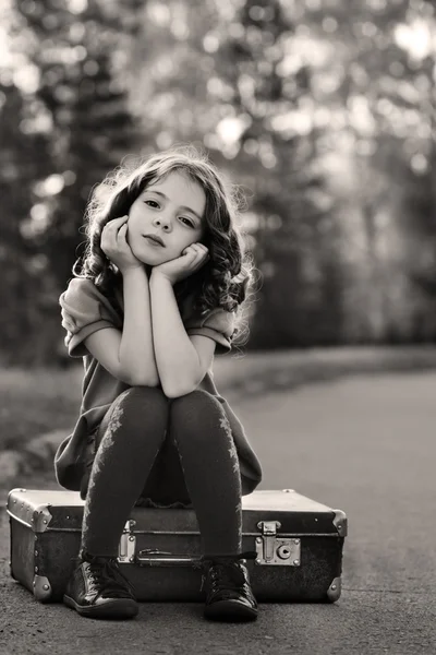 Resentful girl on suitcase — Stock Photo, Image