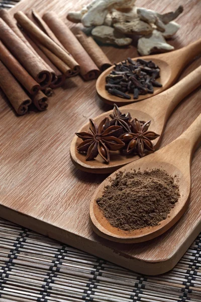 Kruiden en specerijen op houten achtergrond — Stockfoto