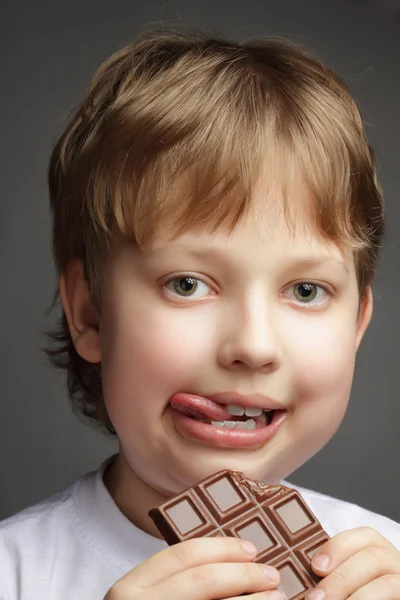 Onnellinen poika suklaapatukalla — kuvapankkivalokuva