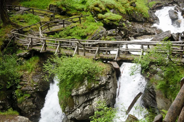 Träbro över saent vattenfall i de italienska bergen — Stockfoto
