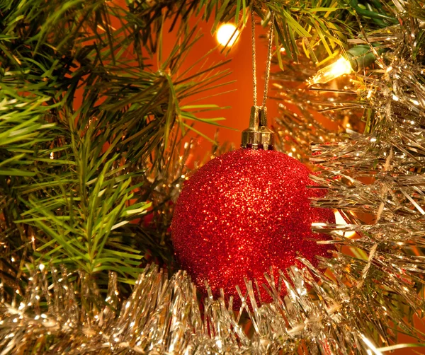 红色圣诞球装饰在树中的圣诞灯点亮 — 图库照片
