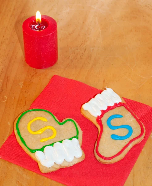 Galletas coloridas de Santa en servilleta roja en una mesa de madera — Foto de Stock