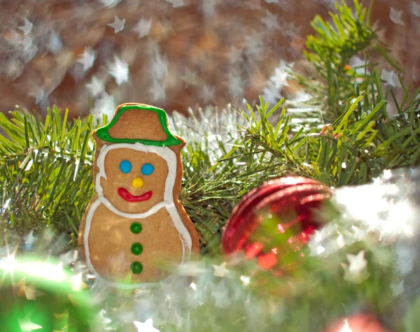 Snowman cookie surrounded by a wreath and Christmas ornaments — Stock Photo, Image