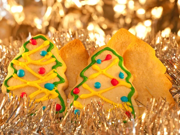 Forest of tree shaped Christmas cookies on silver tinsel — Stock Photo, Image