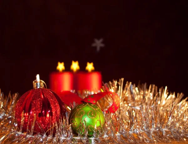 Два рождественских украшения со свечами на заднем плане — стоковое фото