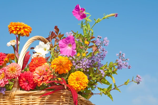 Briljant färgade blommor i en flätad korg — Stockfoto