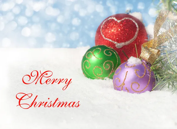 Kerst ornamenten in sneeuw met tekst vrolijk kerstfeest — Stockfoto