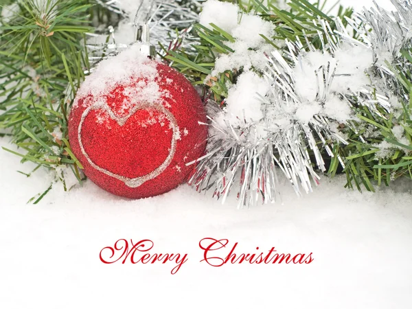 Krans en rode Kerstbal met een hart in sneeuw — Stockfoto