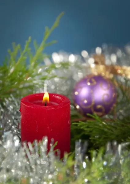 Vela vermelha de Natal queimando, cercada por evergreen — Fotografia de Stock