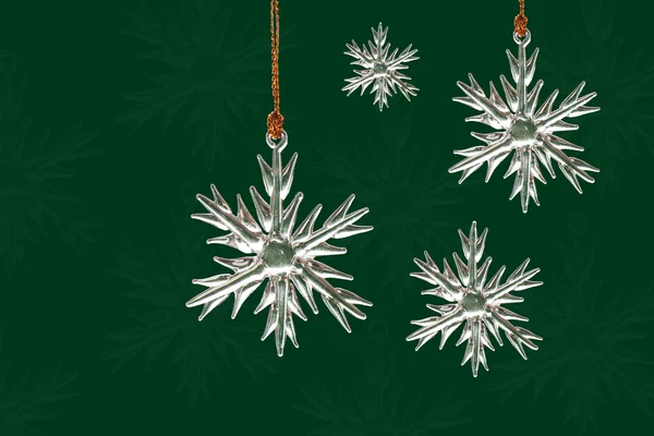 Kristall-Schneeflockenschmuck auf weihnachtsgrünem Hintergrund — Stockfoto