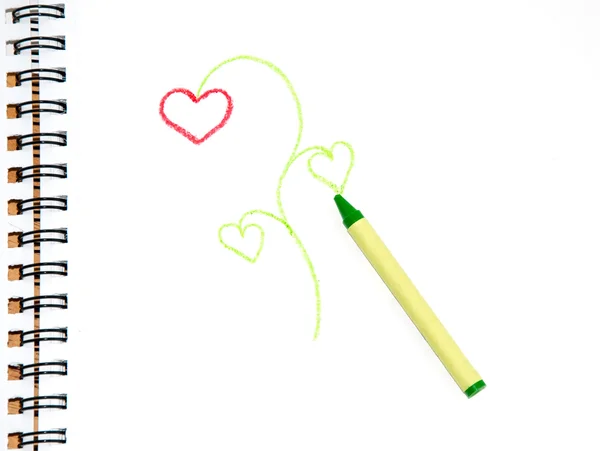 Green crayon on sketch paper with a doodle of a plant — Stock Photo, Image