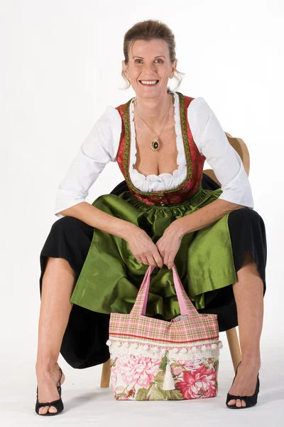 Starsza kobieta w bawarski strój sukienka z torba — Zdjęcie stockowe