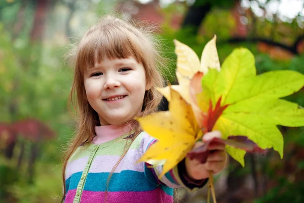Lächelndes Mädchen mit fallenden Blättern — Stockfoto