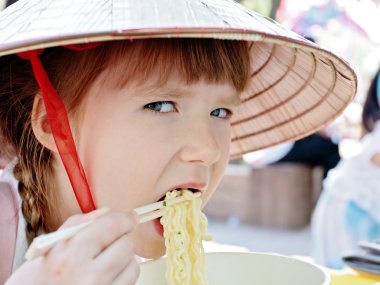 Little girl eating korean style spaghetti (ramen) clipart