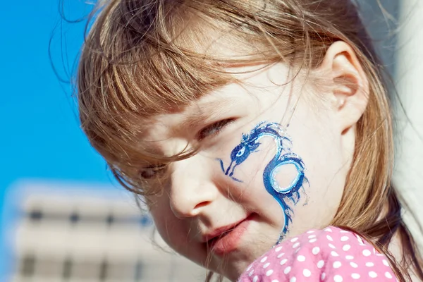 Ritratto di una bambina con drago blu sul viso — Foto Stock