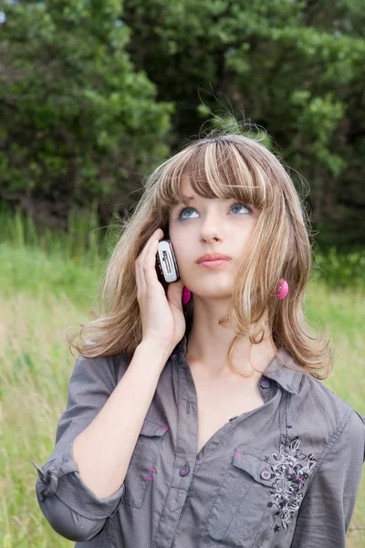 Skolflicka talar med mobiltelefon — Stockfoto