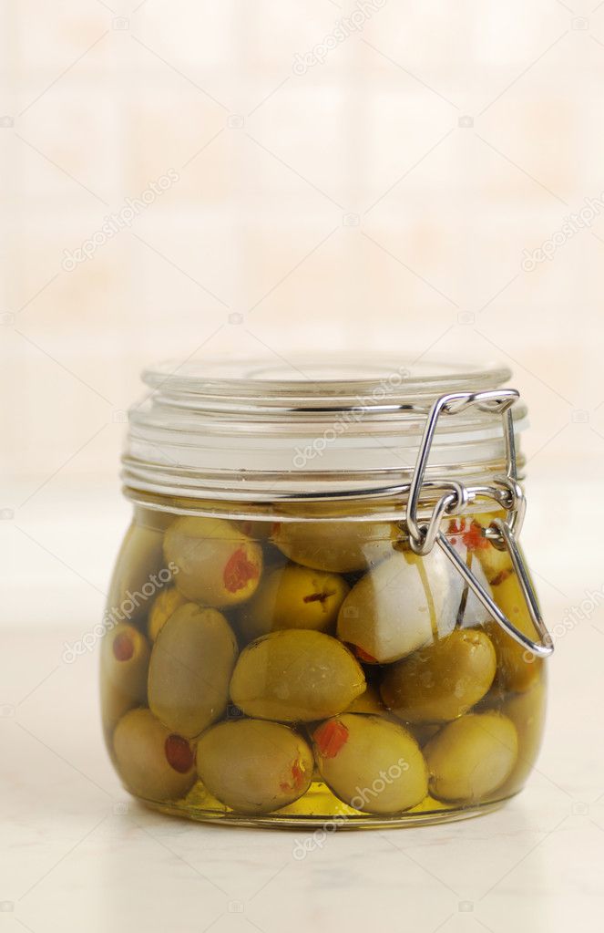 Green pickled olives in glass jar