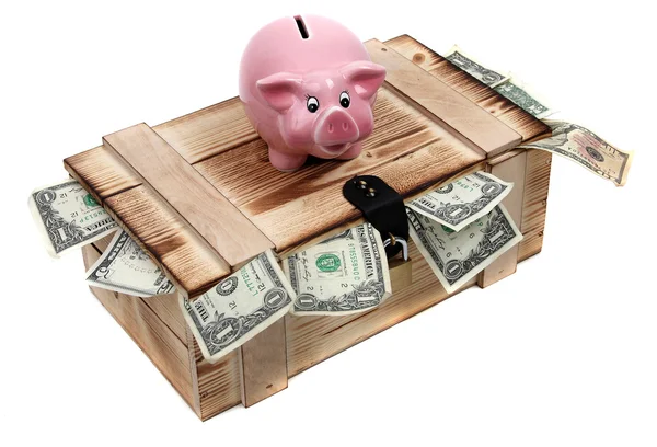 Розовая копилка на деревянном чехле с долларовыми купюрами — стоковое фото