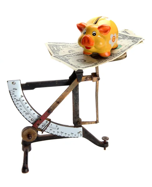 Scales with dollar notes and piggybank — Stockfoto