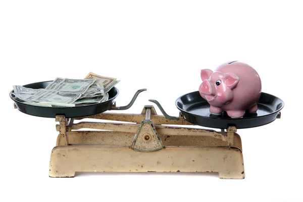 Piggy bank and dollars on scale — Stock Photo, Image