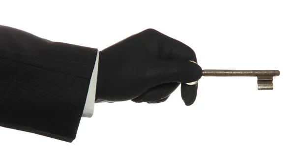 Mão com luva de borracha preta com chave enferrujada velha — Fotografia de Stock