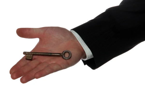 Oude roestige sleutel op palm van de hand — Stockfoto