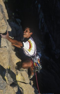 Rock climber struggles. clipart